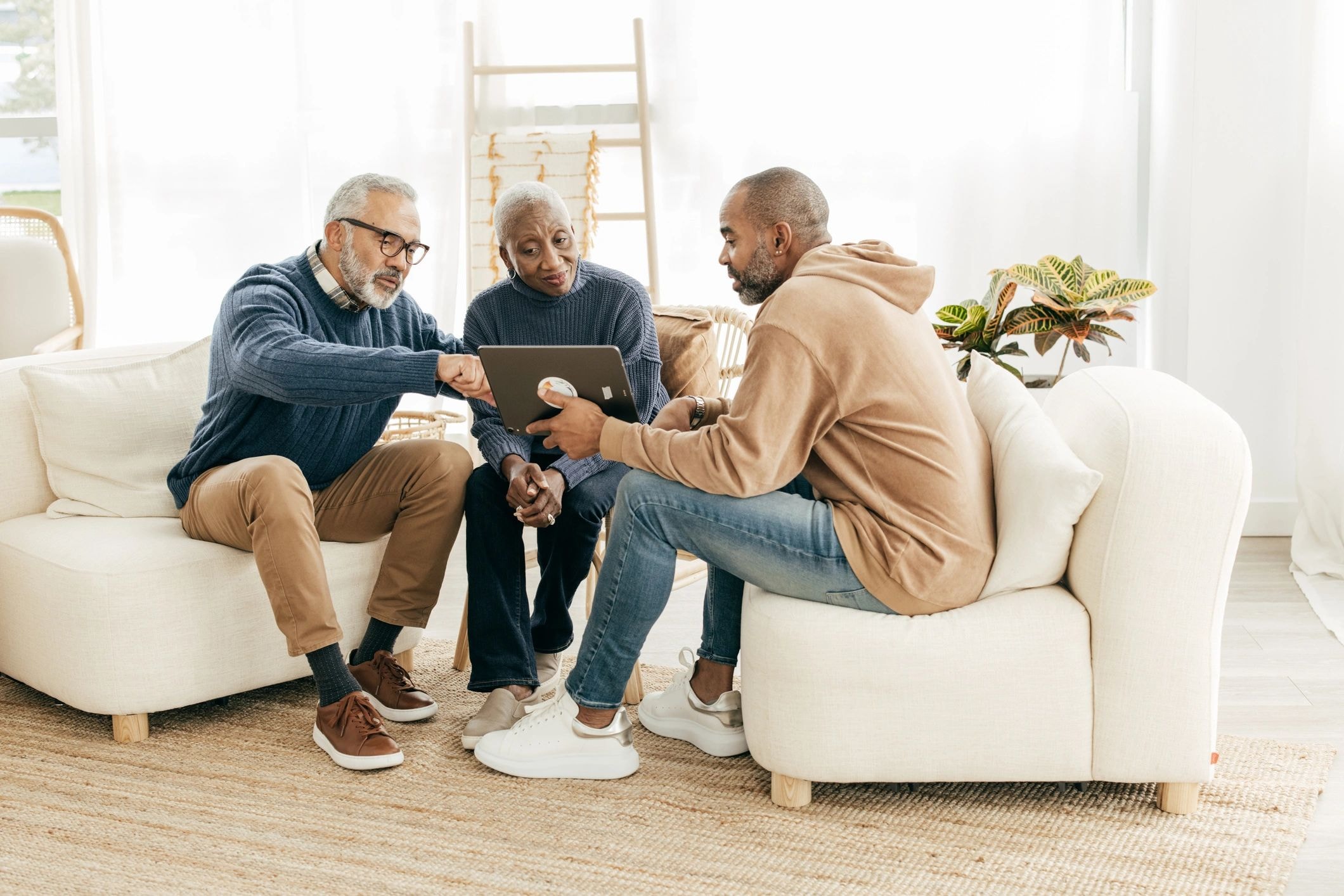 Three professionals discussing tax services on a tablet