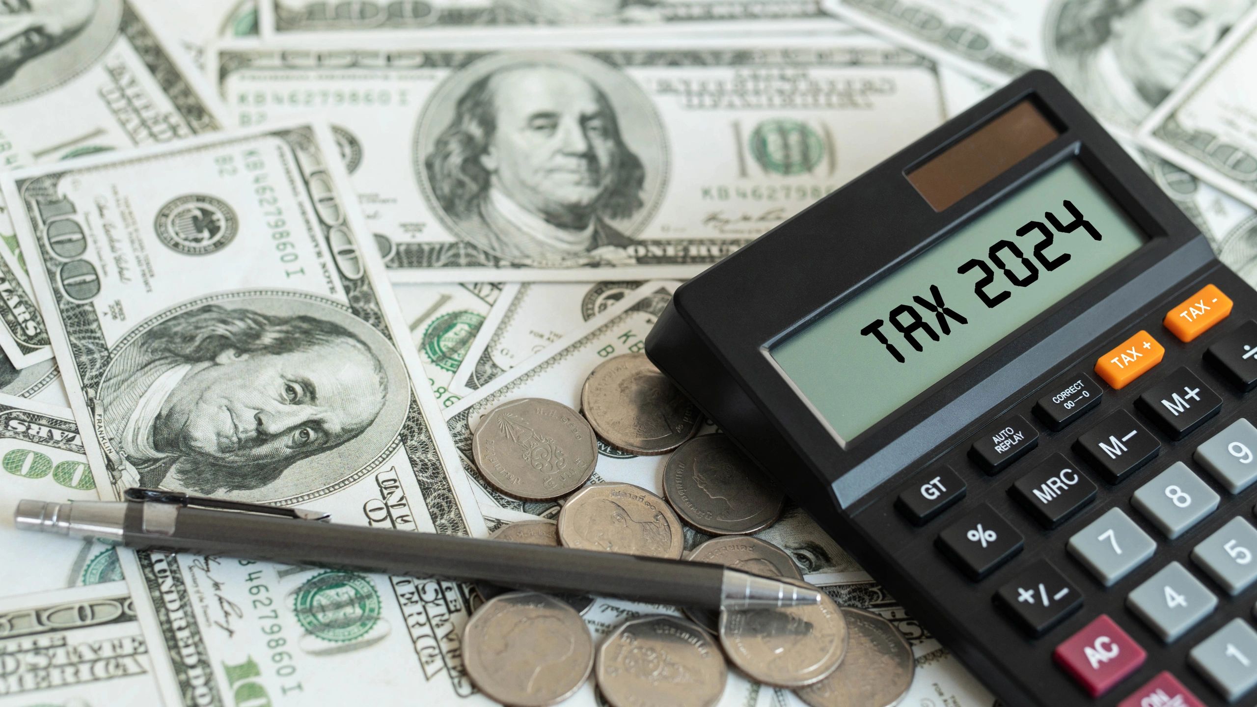 Tax 2024 calculator with dollar bills